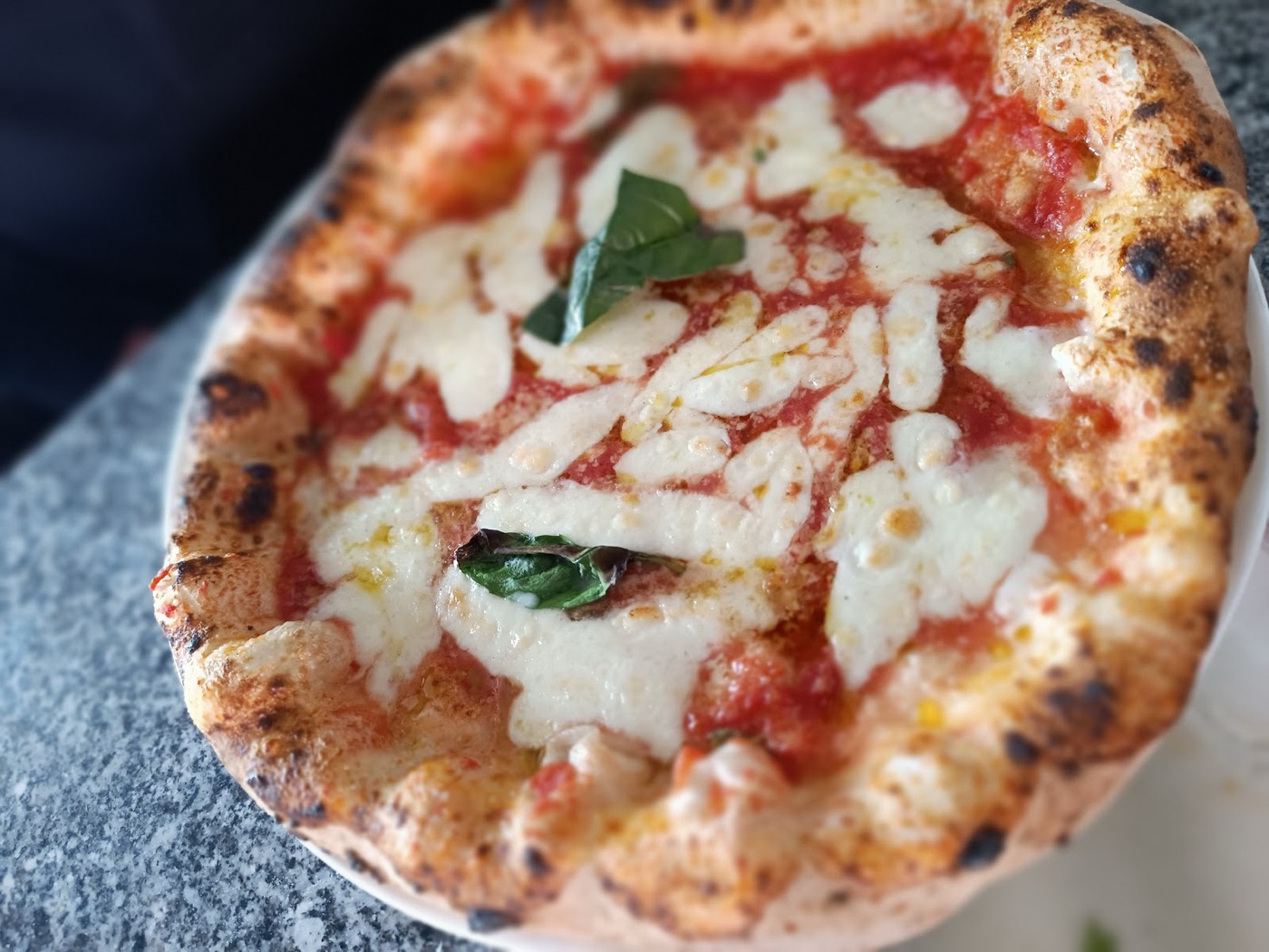 Close up of a classic Neapolitan Margherita pizza with fresh basil