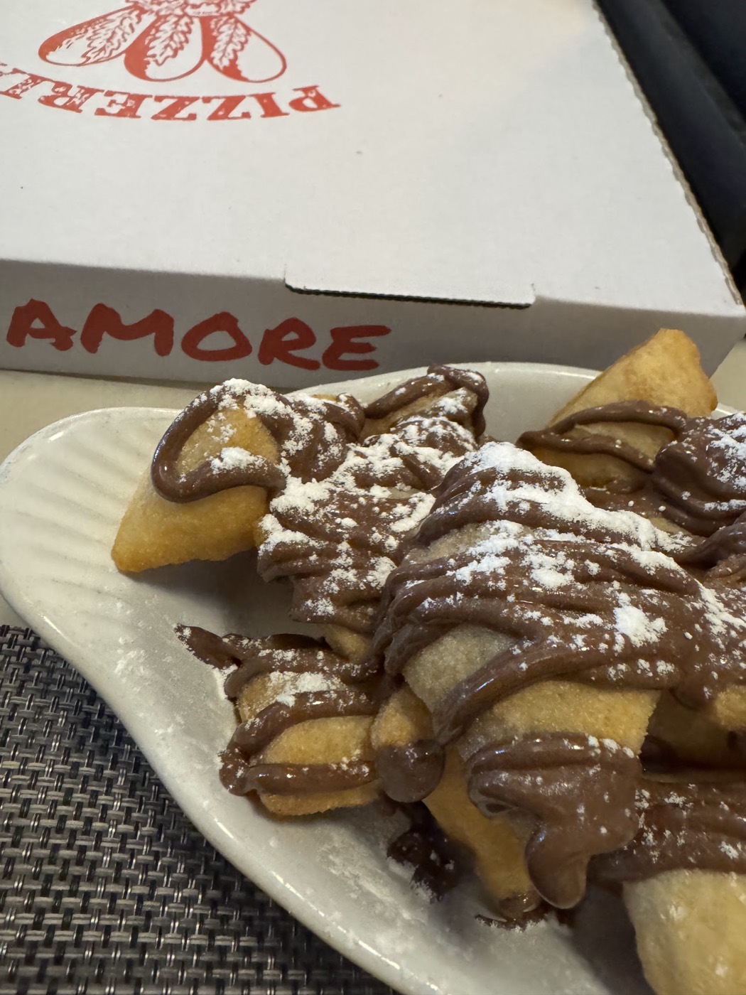 Fried pizza dough pieces drizzled heavily with Nutella